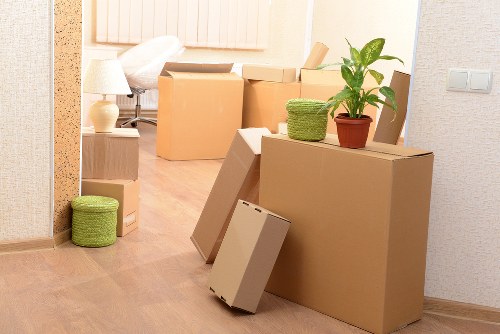 Professional movers carrying boxes through a West Kensington apartment building